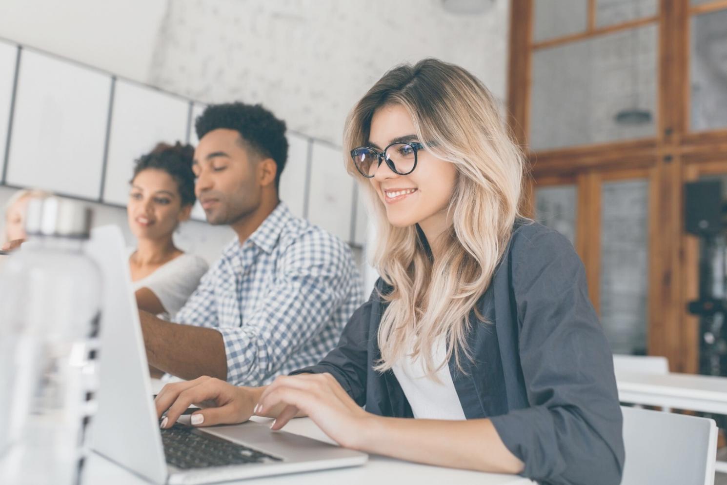 Professional reviewing financial documents and charts on multiple monitors